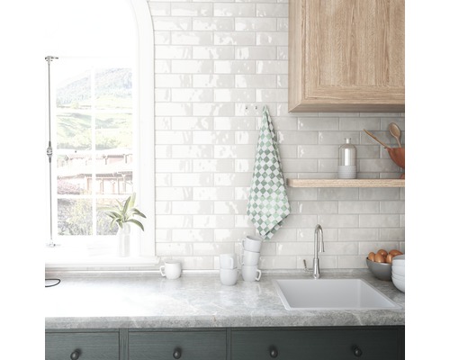 Köksscen med diskho, kakelvägg och fönster