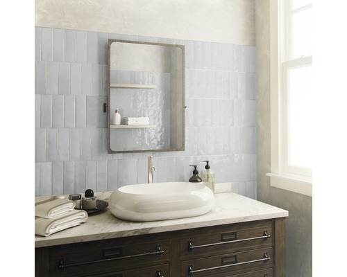 Badrum med handfat, spegel och kakel