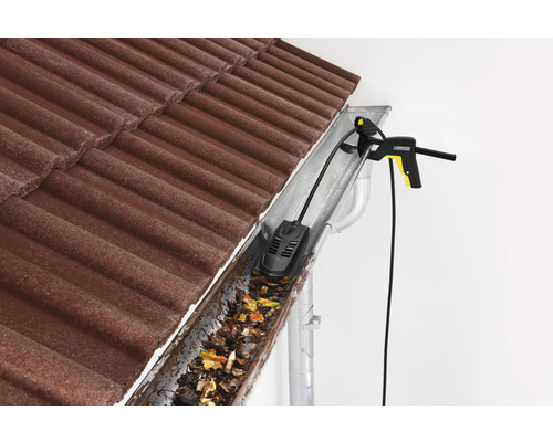 Takrännerengörare i aktion för att ta bort löv och smuts från en takränna