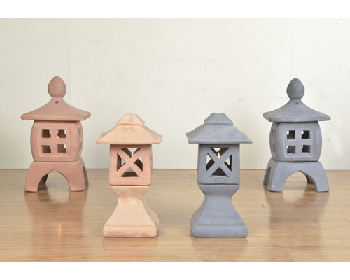 Fyra trädgårdslyktor i sten i olika utföranden