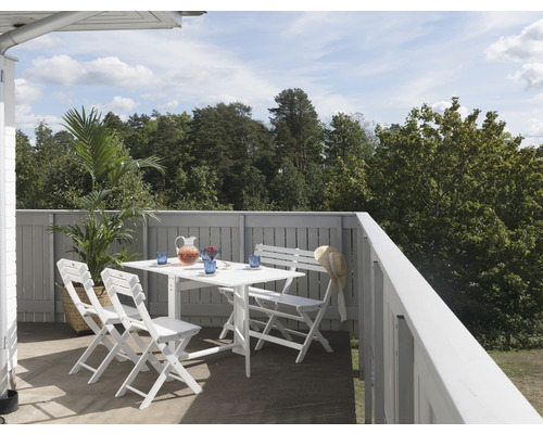 Terrass med vitt trädgårdsbord och stolar