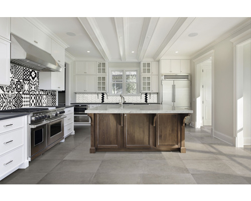 Ljust kök med köksö, klinkergolv och mosaikplattor