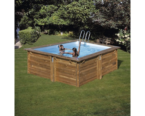 Rektangulär pool av trä med stege i trädgården, två personer i vattnet.