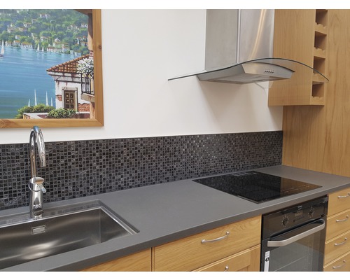 Köksscen med diskho, blandare, mosaikplattor, kokplatta, ugn och köksfläkt.