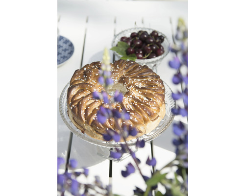 Vetebrödskrans på en glasplatta med körsbär i bakgrunden