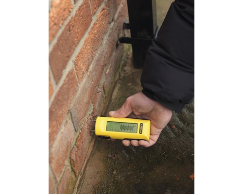 Fuktmätare används på en tegelvägg