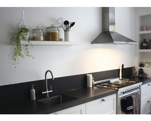 Ljust kök med diskho, spis, fläkt och hyllor