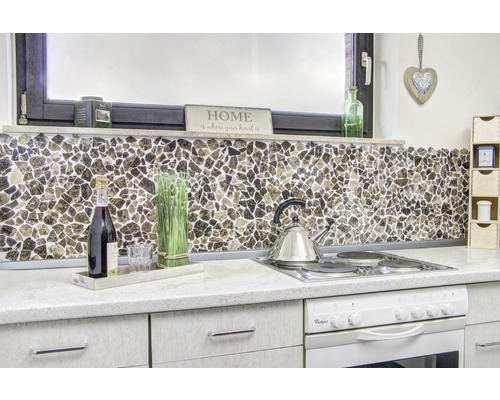 Köksscen med mosaikplattor som stänkskydd, spishäll och dekorationer.