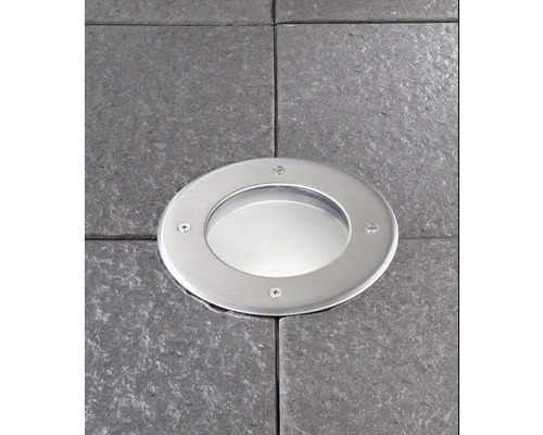 Metallstrålkastare inbäddad i gatsten