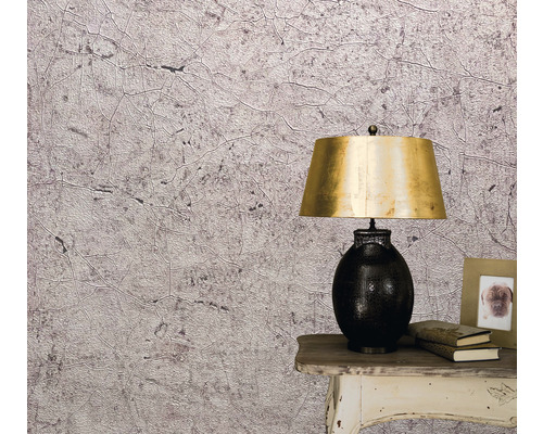 Närbild av en vägg med en tapet med abstrakt mönster, ett nattduksbord och en lampa