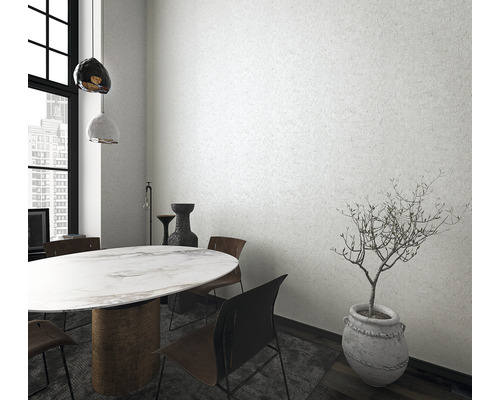 Ljust matsalsrum med matbord, stolar och krukväxt i kruka