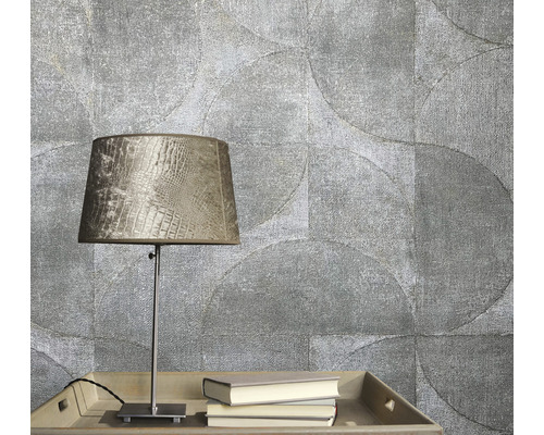 Scen med mönstrad tapet, bordslampa och böcker