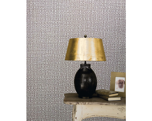 Scen med textiltapet, lampa och dekoration på ett bord