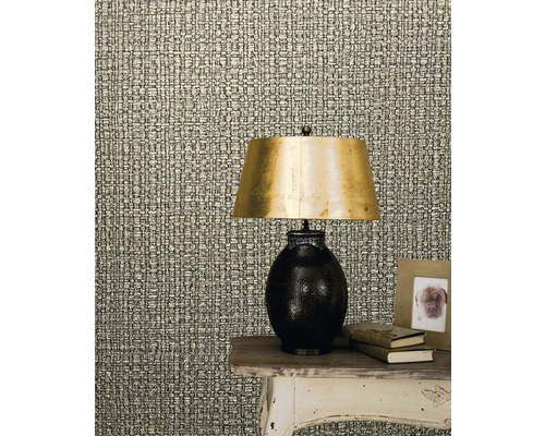 Närbild av en väggbeklädnad med textilmönster bredvid en bordslampa