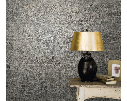 Närbild av en mönstrad tapet på väggen, installerad bredvid ett bord med en lampa och dekorationer