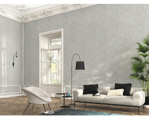 Vardagsrum med grå mönstrad tapet, soffa, fåtölj och krukväxt