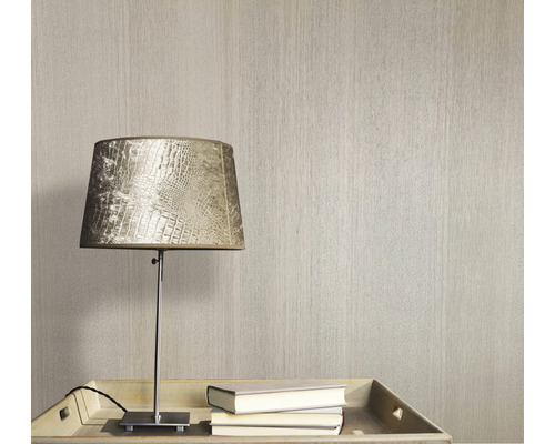 Tapet med textur bredvid en lampa och böcker på ett bord