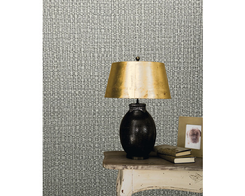 Mönstrad tapet som imiterar textilväv bredvid en lampa på ett bord