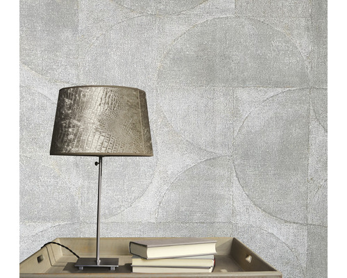 Dekorativ tapet med cirkelmönster, bordslampa och böcker på ett bord