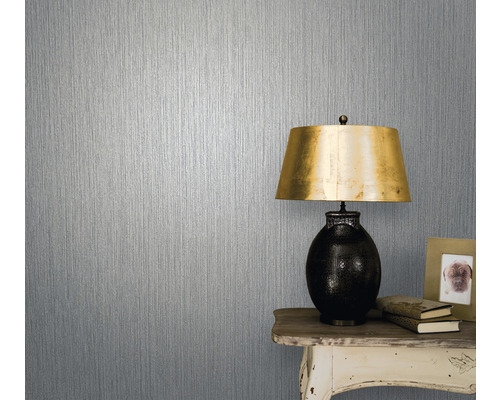 Tapet med vertikalt randmönster bredvid bordslampa på litet bord