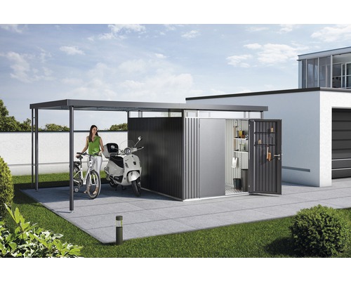 Scen med en redskapsbod, en carport, en skoter och en cykel i trädgården