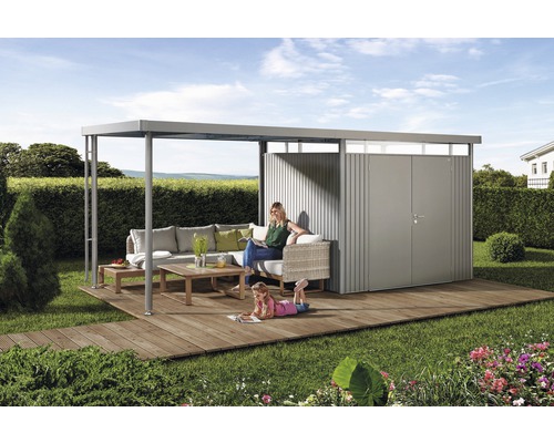 Scen med trädgårdshus med loungehörna på träterrass i trädgården