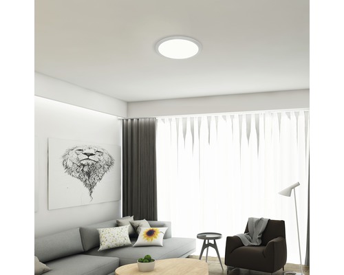 Taklampa i ett ljust vardagsrum med soffa och dekoration.