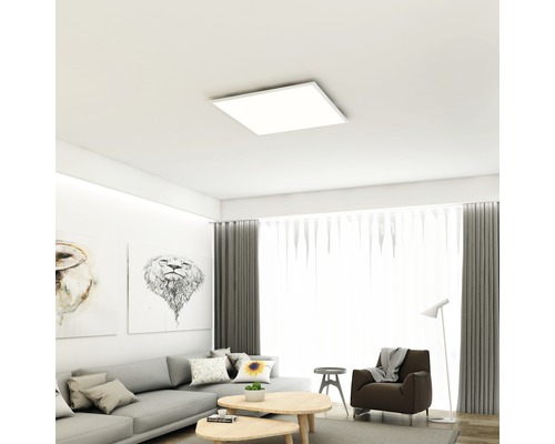 Vardagsrum med grå soffa, bilder och fyrkantig taklampa