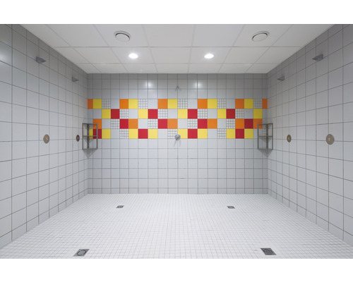 Kaklat duschrum med färgstarka accenter och avloppsrännor