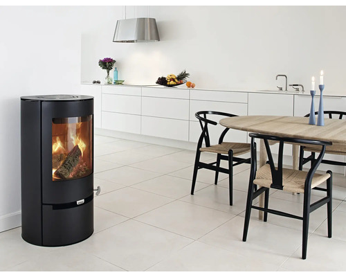 Vardagsrum med vedeldad kamin, matbord och stolar