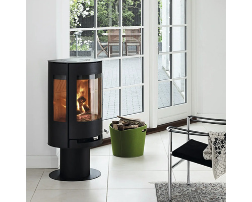 Braskamin med vedkorg i ett ljust rum