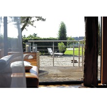 Terrass med trädäck, rostfritt stålräcke och utsikt över trädgården