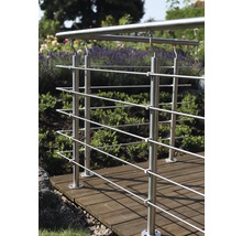 Rostfritt stålräcke på en träterrass i en trädgård.