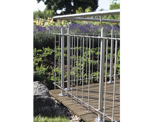 Rostfritt stålräcke på en träterrass i en trädgård