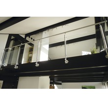 Interiörbild av ett hus med galleri, rostfritt stålräcke och glaspaneler