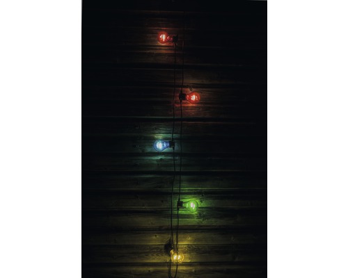 Dekorativ ljusslinga med mångfärgade glödlampor framför en trävägg