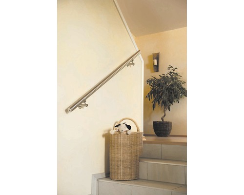 Trapphus med rostfritt stålräcke och rottingkorg på trappsteg