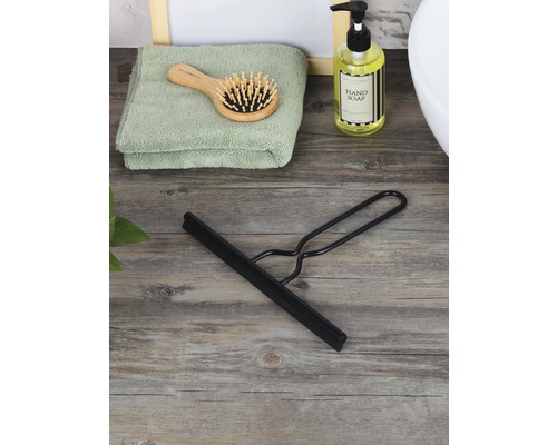 Svart duschskrapa på träunderlag