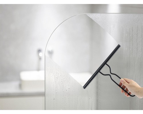 Hand som torkar av en duschvägg med en fönsterskrapa