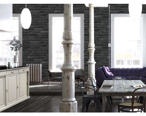 Ljust vardagsrum med tapet i stenimitation, matbord, soffa och pelare
