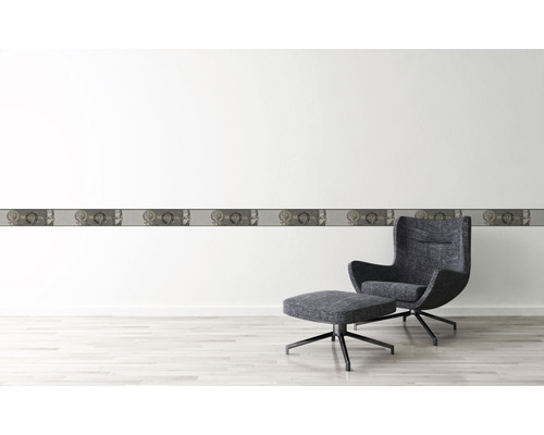 Väggdekoration med bård och fåtölj i ett ljust rum.