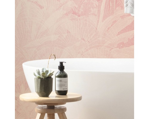 Badrum med rosa mönstrad tapet, badkar, suckulent och lotion på en pall