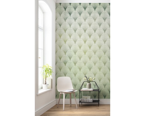 Vardagsrum med grönt tapetmönster med solfjädrar, stol och sidobord.