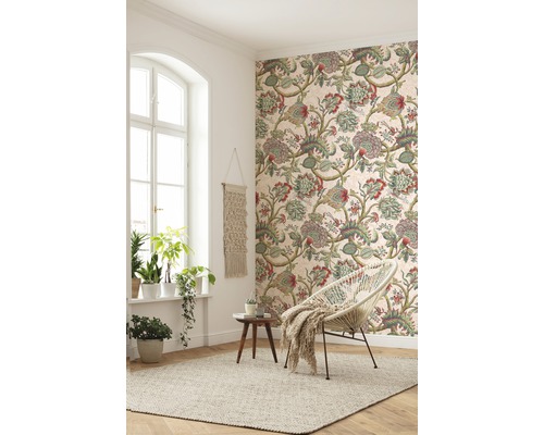 Vardagsrum med mönstrad tapet, fåtölj och matta