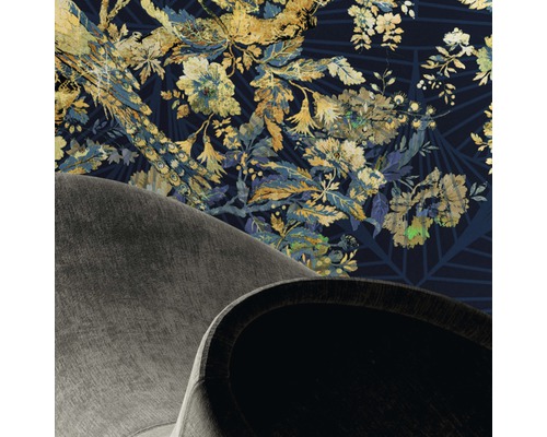 Detaljvy av ett rum med blommönstrad tapet och delvis synlig fåtölj.