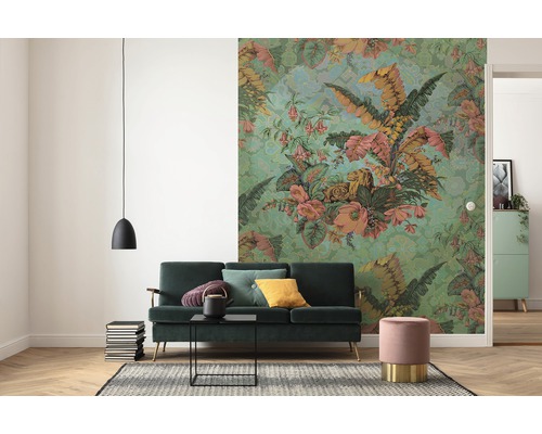 Vardagsrum med grön soffa, blommig tapet och hänglampa