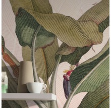 Detaljbild av ett rum med en tapet med bananbladsmotiv, en hylla, en kanna och en kopp