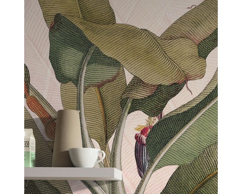 Detaljbild av ett rum med en tapet med bananbladsmotiv, en hylla, en kanna och en kopp