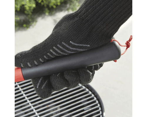 Grillhandske håller grillspett