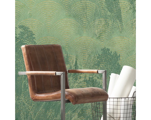 Rumsöversikt med grön tapet, brun fåtölj och papperskorg